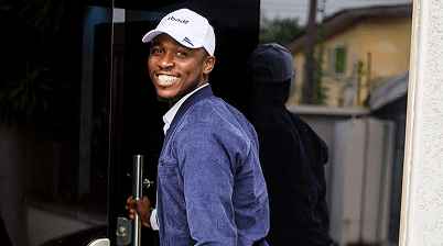 Jeffery smiling while opening a door